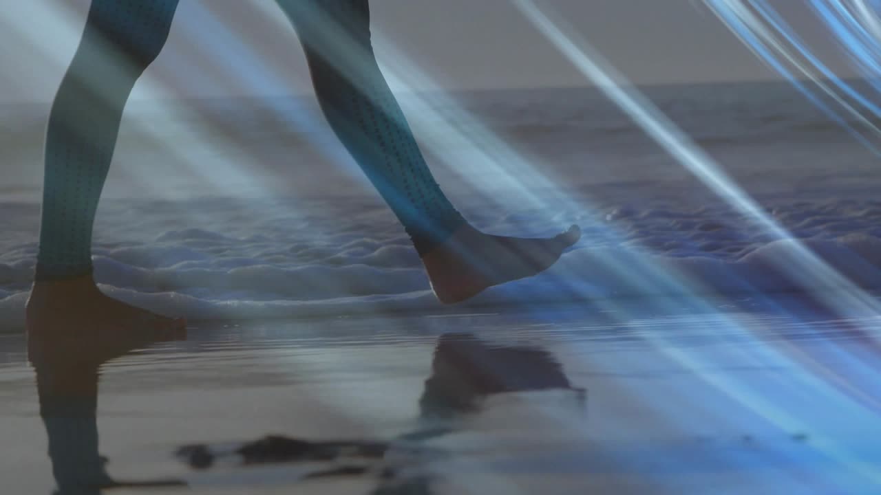 Donna che cammina sulla riva, il tallone colpisce la risacca, schizzando, con un'interfaccia blu che attraversa le gambe, per un viaggio.