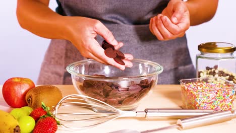 preparing chocolate discs with fruits and sprinkles