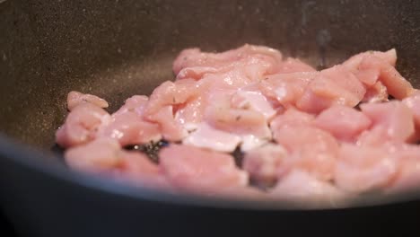 cocinar carne de pollo, asar carne de pollo en una sartén en la cocina por un cocinero italiano