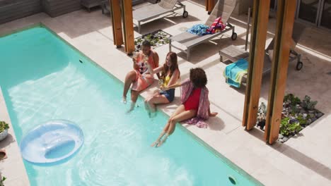 diverse group of female friends having fun drinking wine at pool