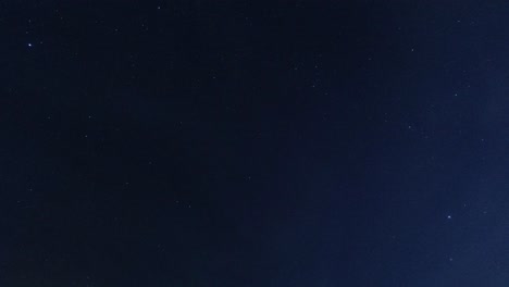 time lapse looking up at clouds passing sparkling stars in the clear night sky