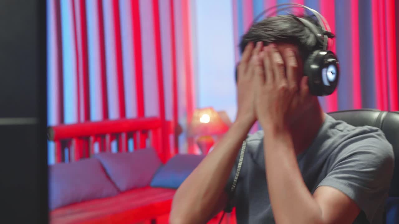 Male Gamer Wearing Headphones Feeling Upset, Losing Video Game