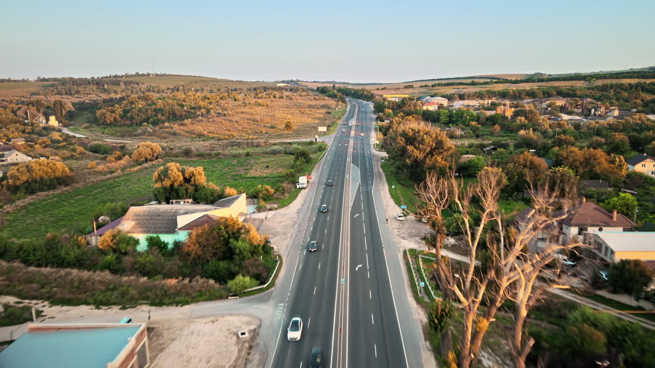 Aerial drone view of Tipova, Moldova at sunset. Road with cars, residential buildings, greenery