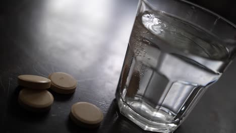 effervescent vitamin c supplement tablet dissolving in glass of water