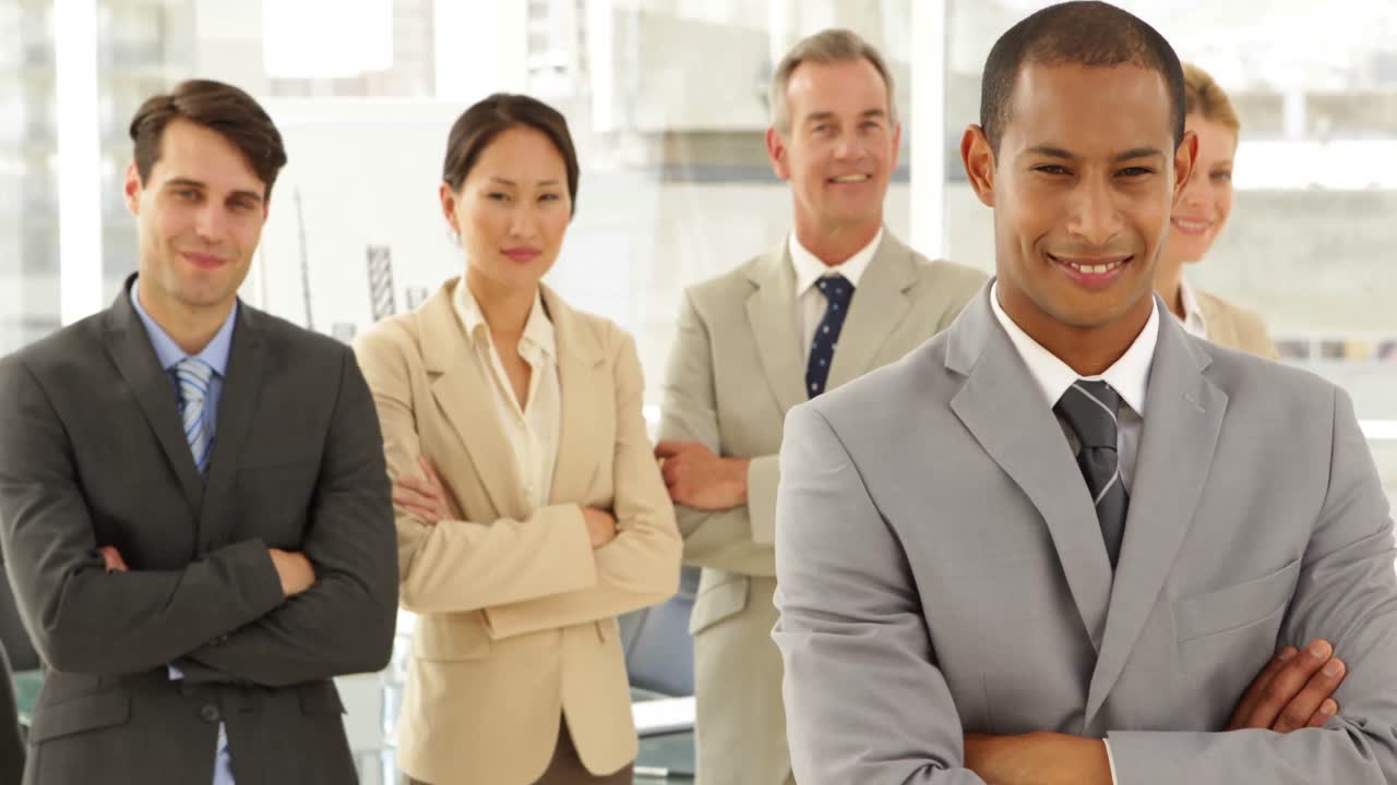 hombre de negocios sonriendo a la cámara frente a su personal