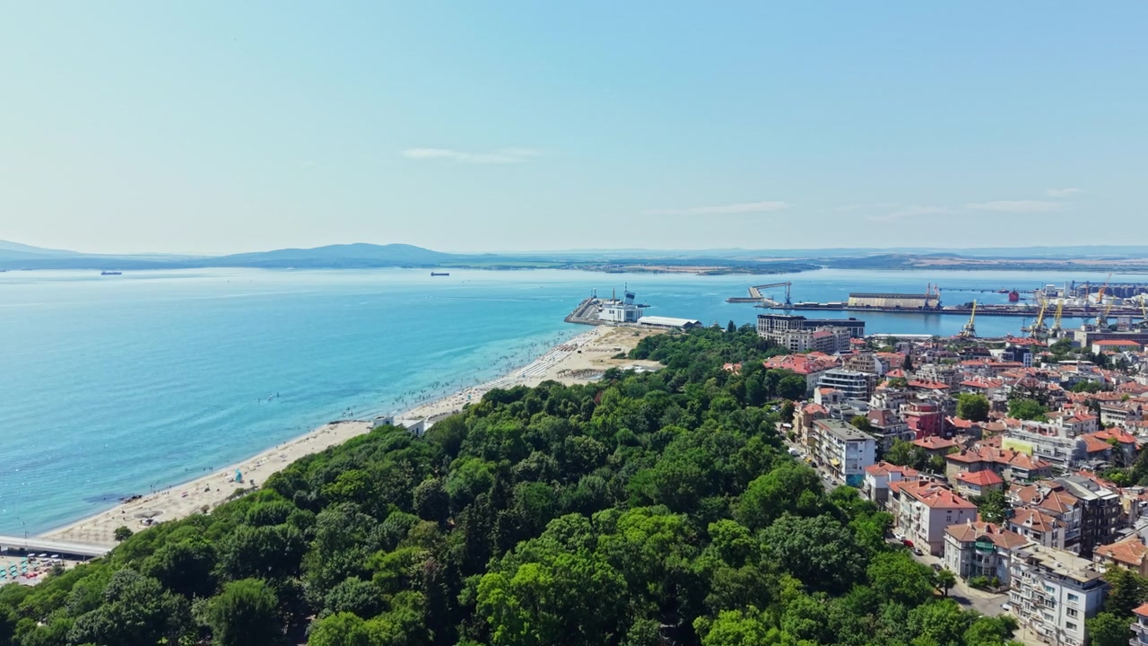 Vista panoramica della costa con edifici, spiaggia e mare durante una giornata serena.
