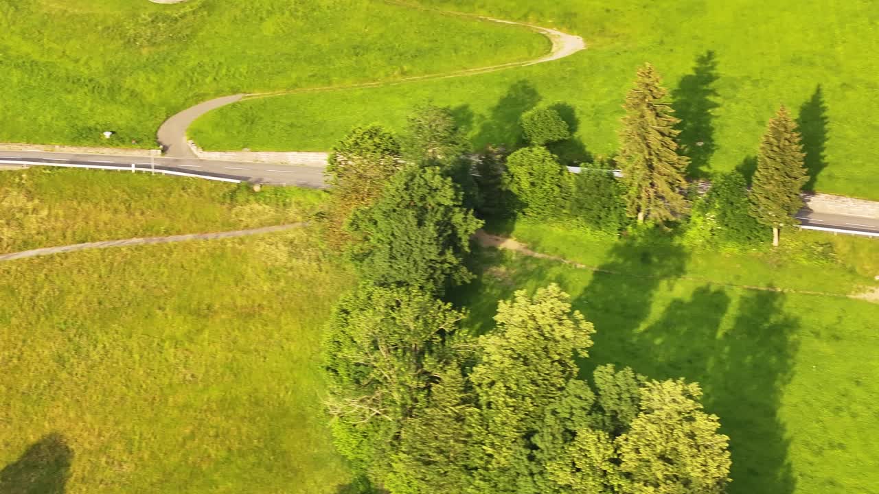 yellow bus driving along a winding mountain road near Fronalpstock. Filzbach, Molis, Kanton Glarus, Switzerland