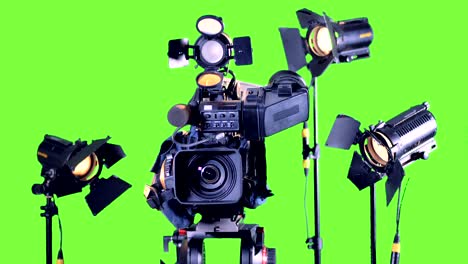 bright spotlights stand near professional video camera on a green screen.