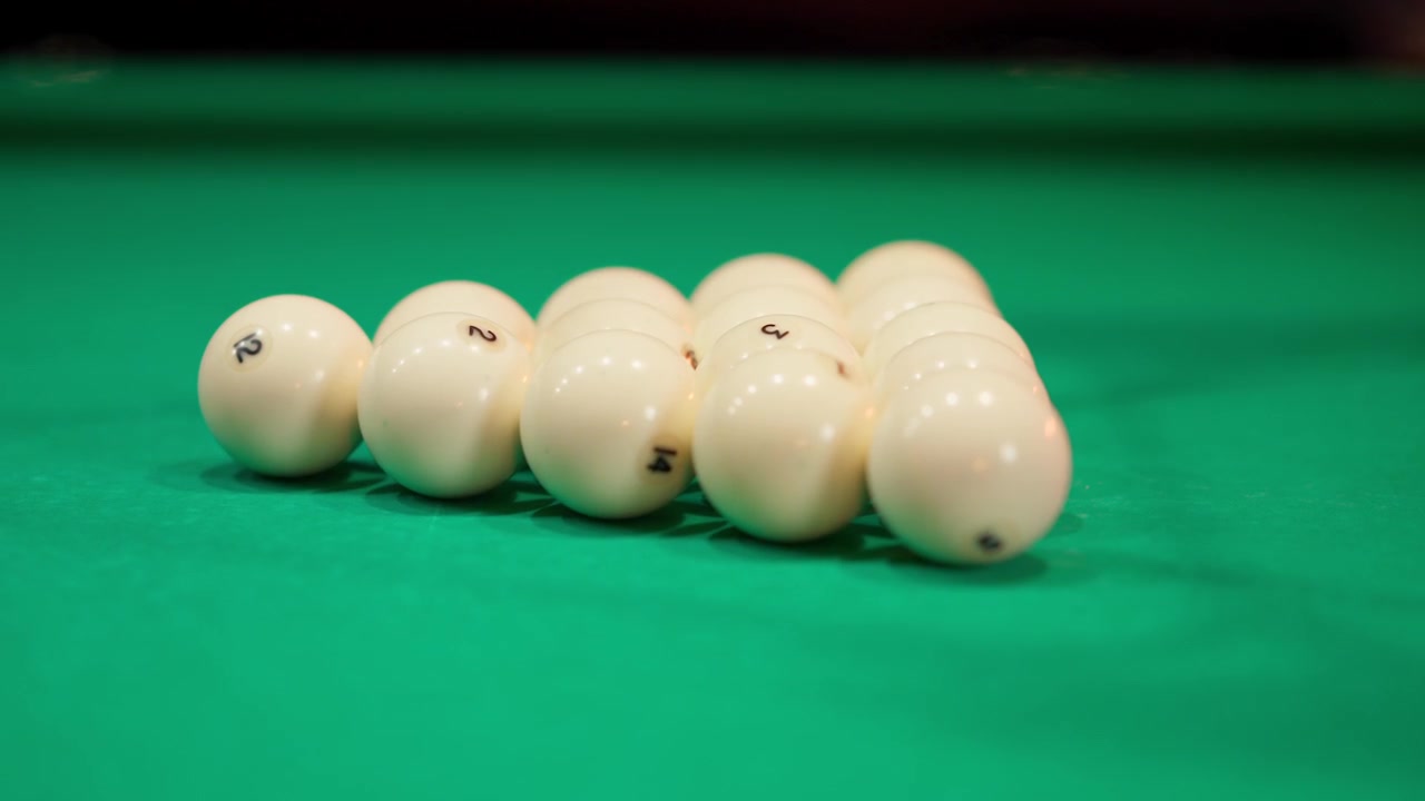 Hands Racking Billiard Balls on Green Pool Table