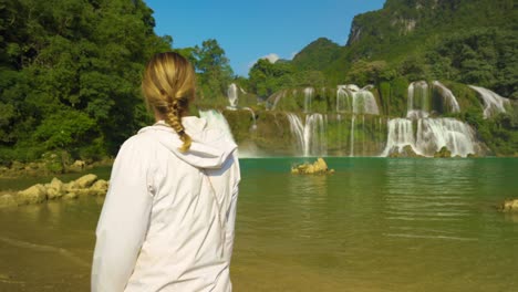 siguiendo a una mujer explorando y mirando una cascada. ban gioc concepto de pasión por el viaje a lo largo de la frontera de vietnam china