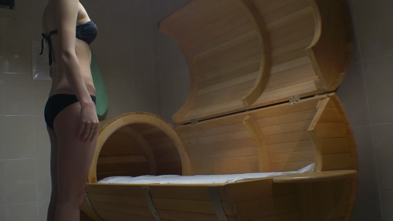 나무 배럴 사우나 에 있는 여자