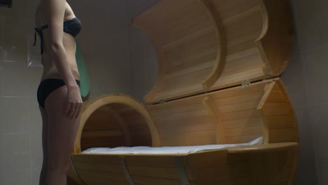 woman in a wooden barrel sauna