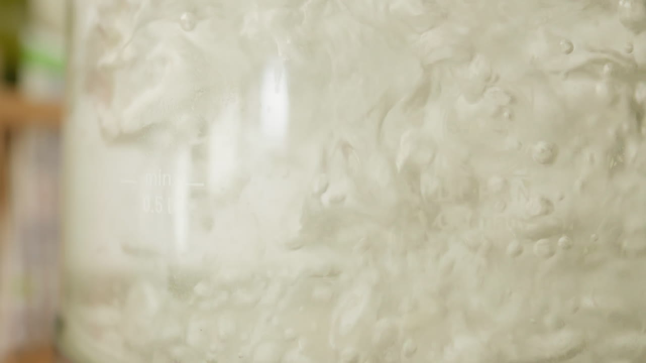 agua hirviendo de cerca, burbujas vigorosas en una tetera transparente