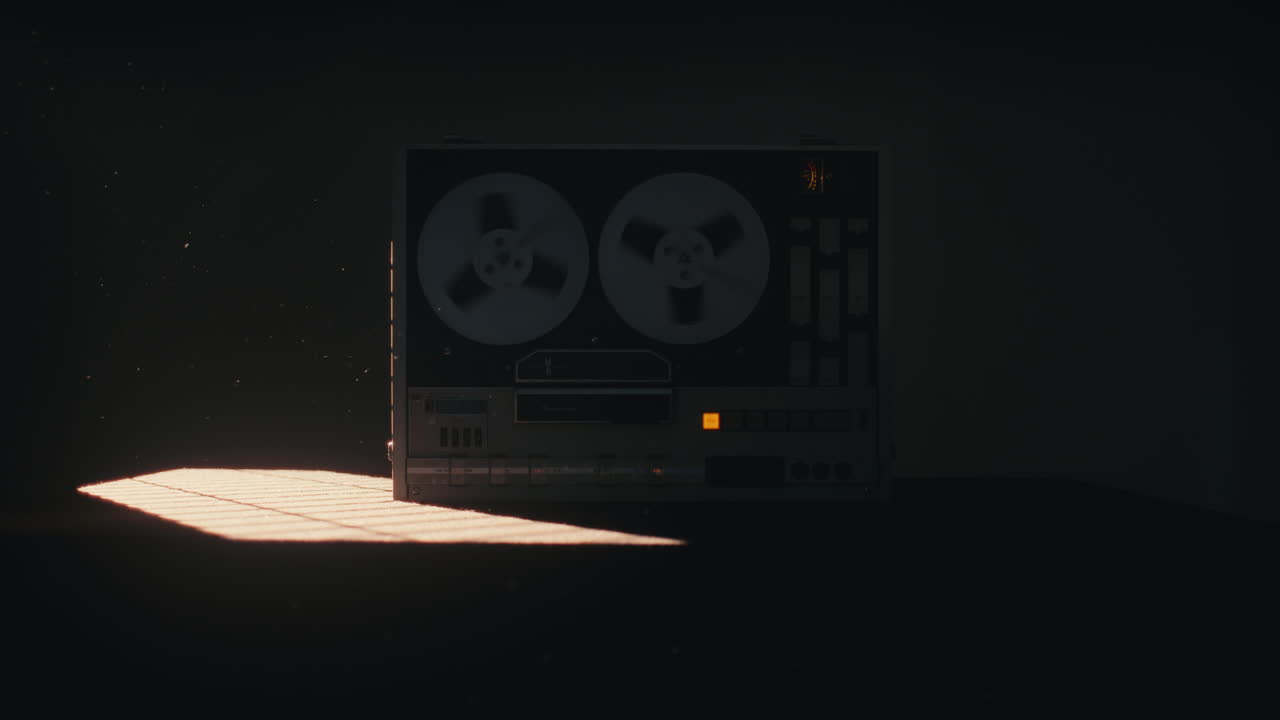 A vintage tape recorder spinning spools in a red blinking light
