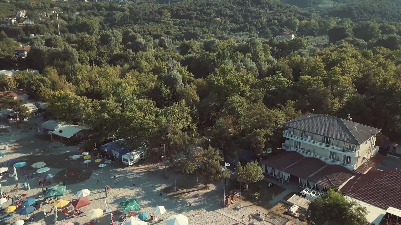 Aerial view of a beach with umbrellas and trees