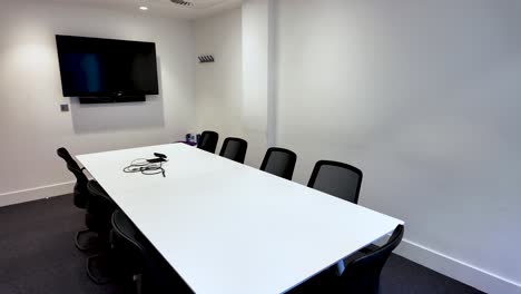 large conference room with minimalistic design, equipped with furniture and technology tools. pan right