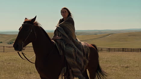 woman on horseback in a vast rural landscape