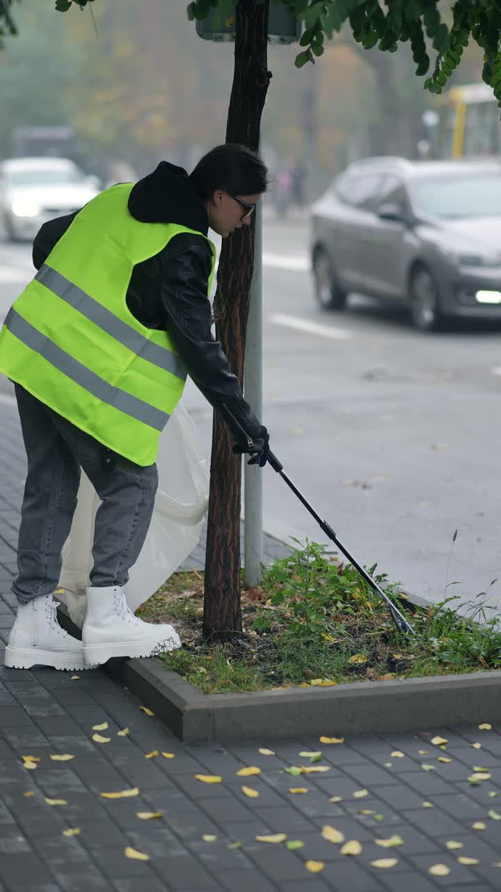 mujer limpiando la basura en la calle de la ciudad