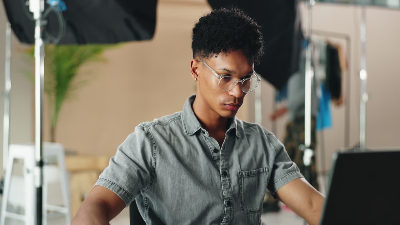 Man Working on Laptop in Photography Studio