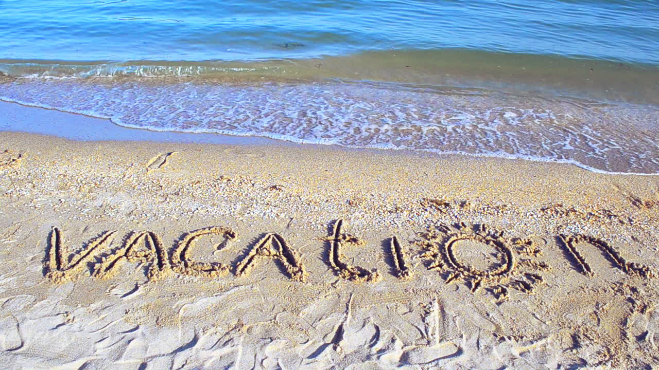 The inscription Vacation on sand. Inscription on sand