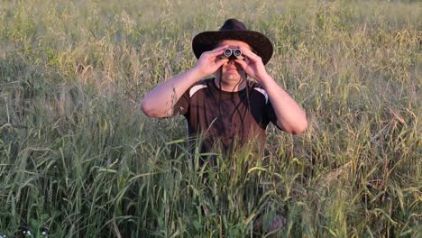 young traveler man holding binoculars on the mountains young traveler man holding binoculars in the field