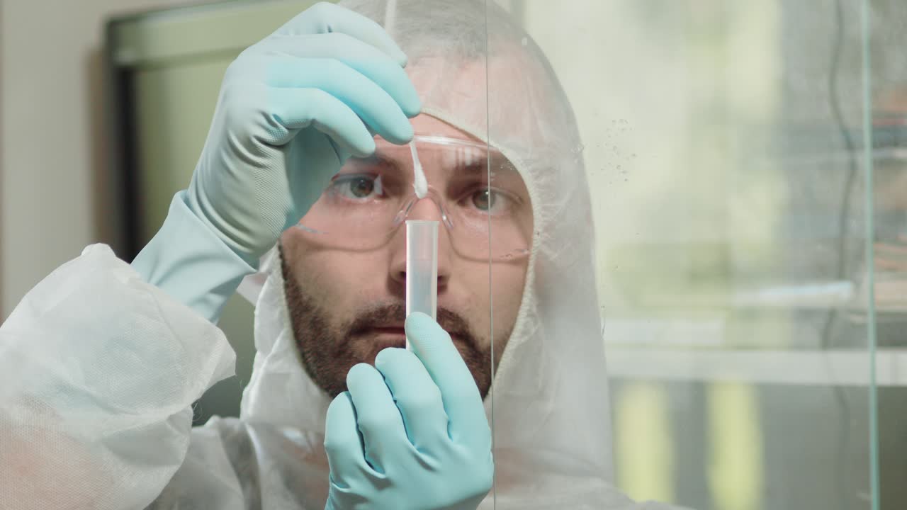 Forensic investigator sampling spittle into test tube for DNA analysis, closeup
