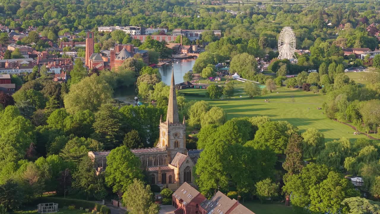 Un'orbita di drone intorno alla Chiesa Gotica della Santissima Trinità, che volteggia intorno alla guglia per rivelare il serpeggiante fiume Avon e lo storico centro di Stratford-upon-Avon sullo sfondo.
