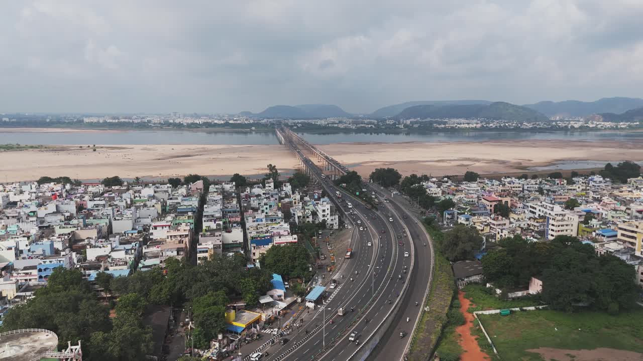 Aerial video of vijayawada, a bustling metropolis near the Andhra Pradesh capital of Amaravati the city's vibrant urban tapestry. The majestic Krishna River winds its way through the landscape