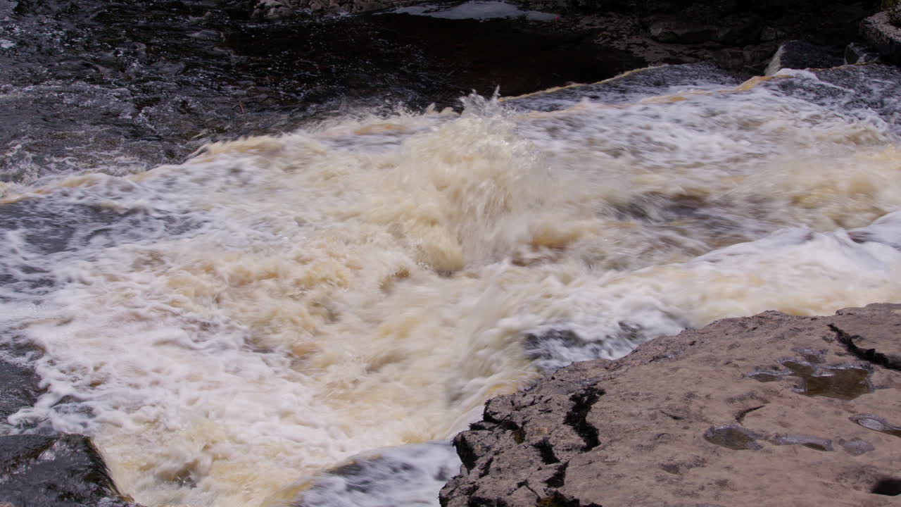 요크셔 스 (yorkshire dales) 의 우리 강 (ure river) 에 있는 아이스가르트 폭포 (aysgarth falls) 의 하부 폭포를 가로질러 아오르는 물의 상단 사진