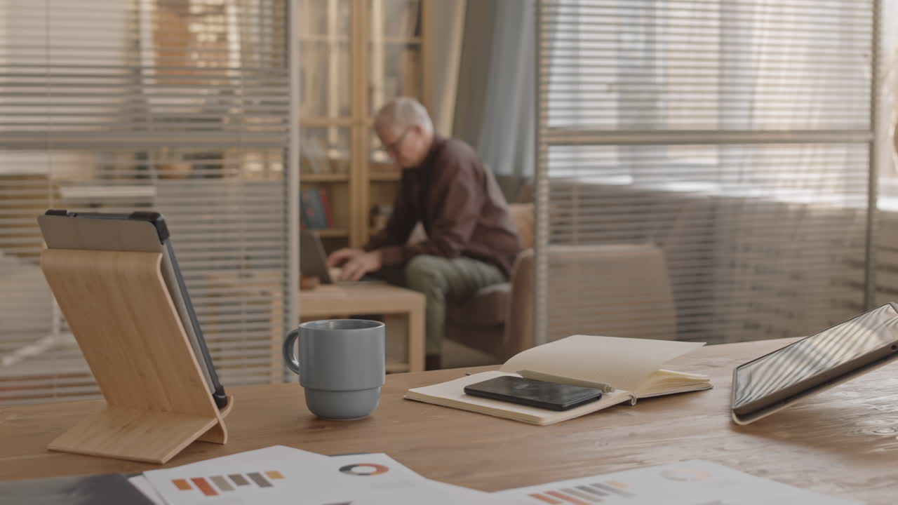 Workspace with technology and older man working