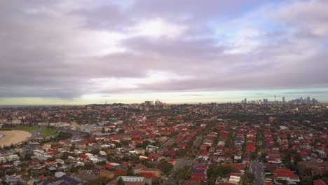 Toma-Panorámica-De-Una-Hermosa-Playa,-Pueblo-Y-Ciudad-Con-Cielo-Aterciopelado-Durante-El-Amanecer-En-La-Mañana