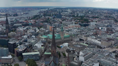 Aerial-view-of-historic-city-centre.-Parallax-effect-of-tall-towers-of-city-hall-and-churches-while-flying-above-town.-Free-and-Hanseatic-City-of-Hamburg,-Germany