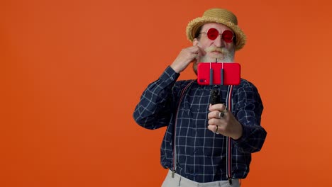 Blogger-Viajero-Abuelo-Senior-Con-Gafas-De-Sol,-Tomando-Selfie-En-Un-Smartphone,-Videollamada-En-Línea