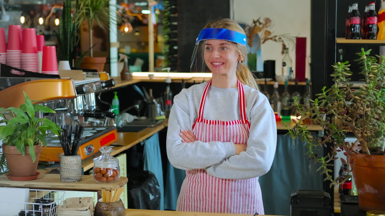 бариста в защитном щите в кафе.