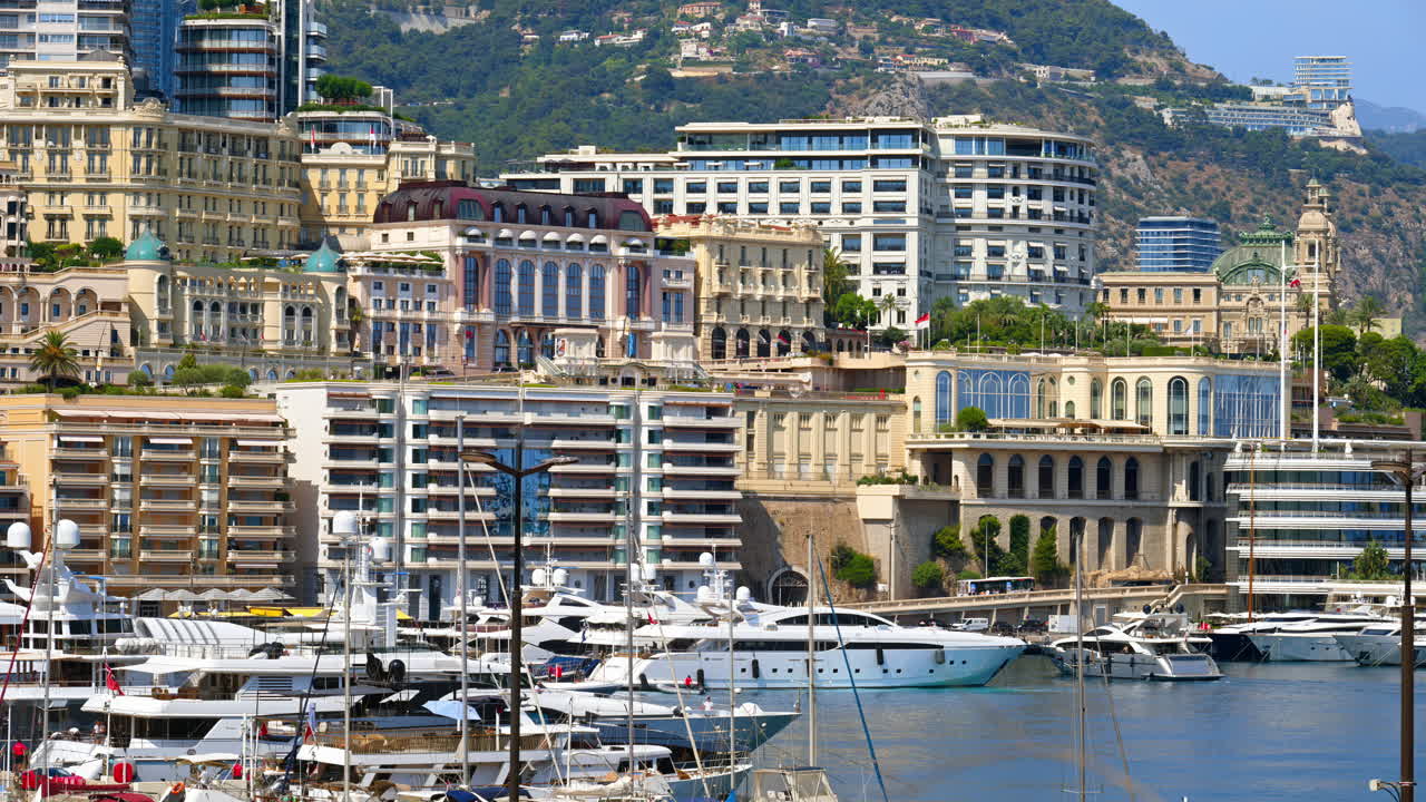 View of boats docked in the Monaco Marina with the skyline of the city on the background