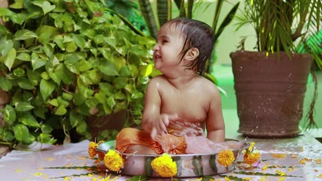 cute toddler baby boy bathing in decorated bathtub at outdoor from unique perspective