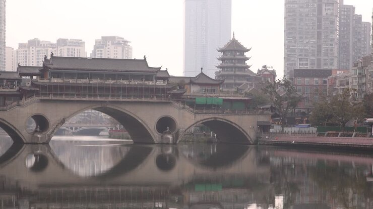 Chengdu capital city of the Chinese province of Sichuan, Anshun Bridge over the Jin river with modern skyline skyscraper building in background , ari pollution smog concept in metropolitan area