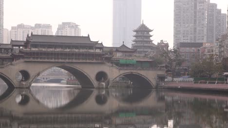 chengdu capital city of the chinese province of sichuan, anshun bridge over the jin river with modern skyline skyscraper building in background , ari pollution smog concept in metropolitan area