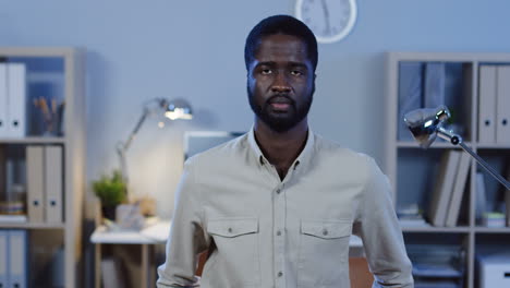 young office worker looking at camera doing no gesture with a finger in the office at night