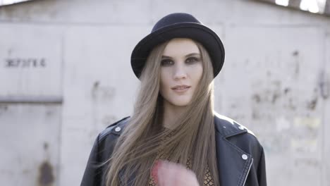 mujer elegante con sombrero negro y chaqueta de cuero