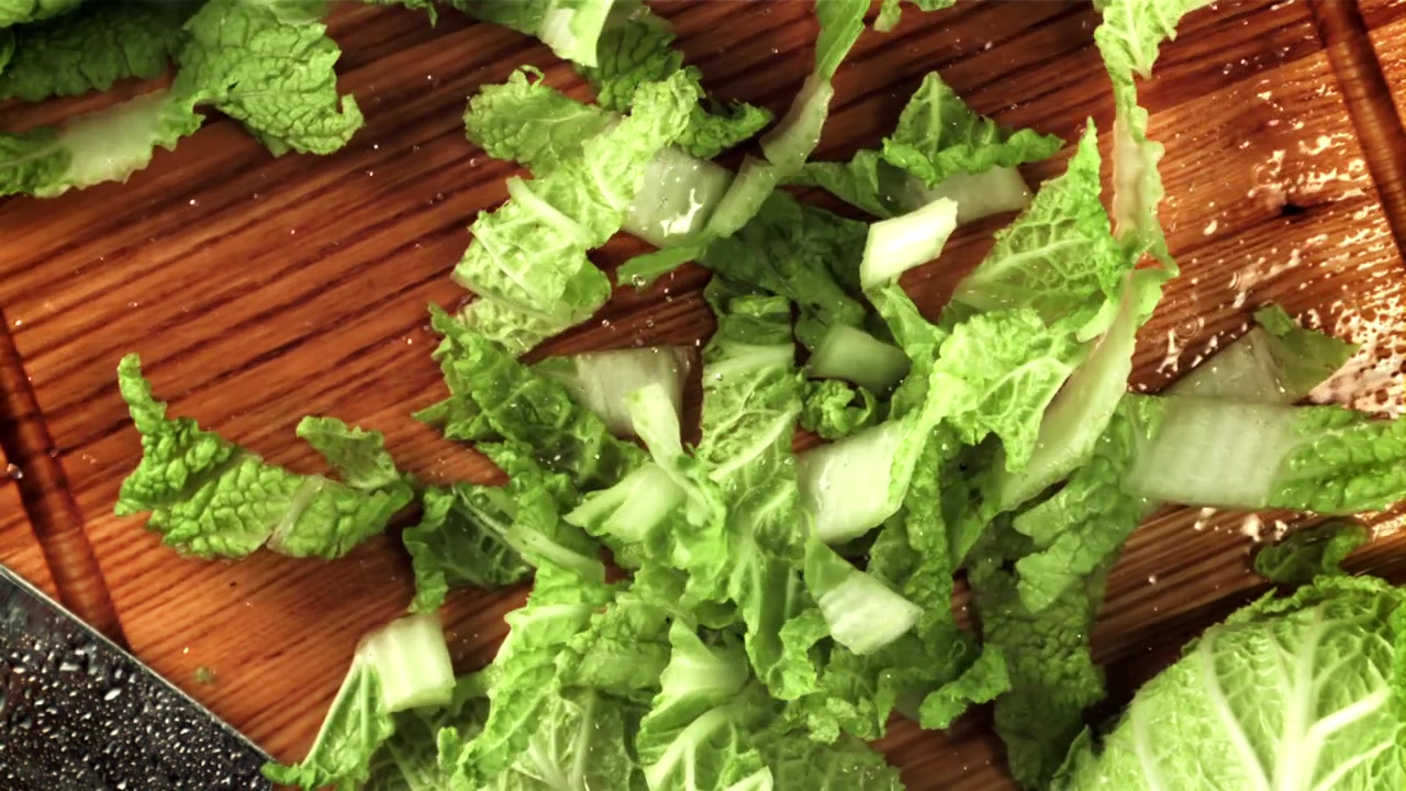 Fresh Chopped Lettuce Falling onto a Wooden Cutting Board