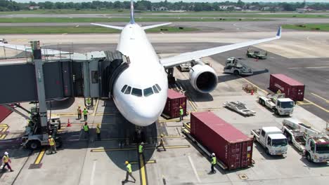 aircraft ground operations: personnel managing loading and unloading of cargo and passengers at airport gate with ground services in action