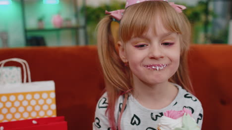 young little children girl with lots of gift presents celebrating birthday party eating dessert cake
