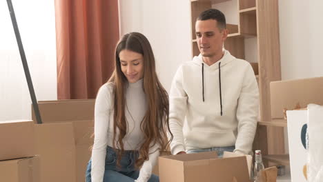 happy couple moving house packing their belongings and kissing 1