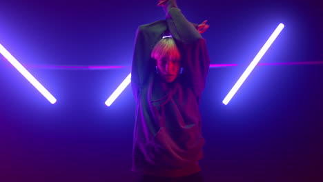 professional dancer girl moving hands energetic in ultraviolet lights close up.