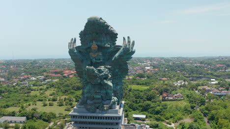 Umkreist-Eine-Majestätische-Garuda-Wisnu-Kencana-Statue-In-Bali,-Indonesien.-Riesige-Religiöse-Monumentskulptur-Von-Vishnu,-Die-Garuda-Reitet,-Die-Sich-über-Der-Stadt-Erhebt