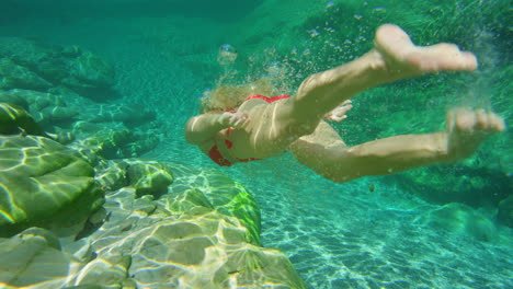 A-woman-enjoying-an-underwater-swim-in-her-red