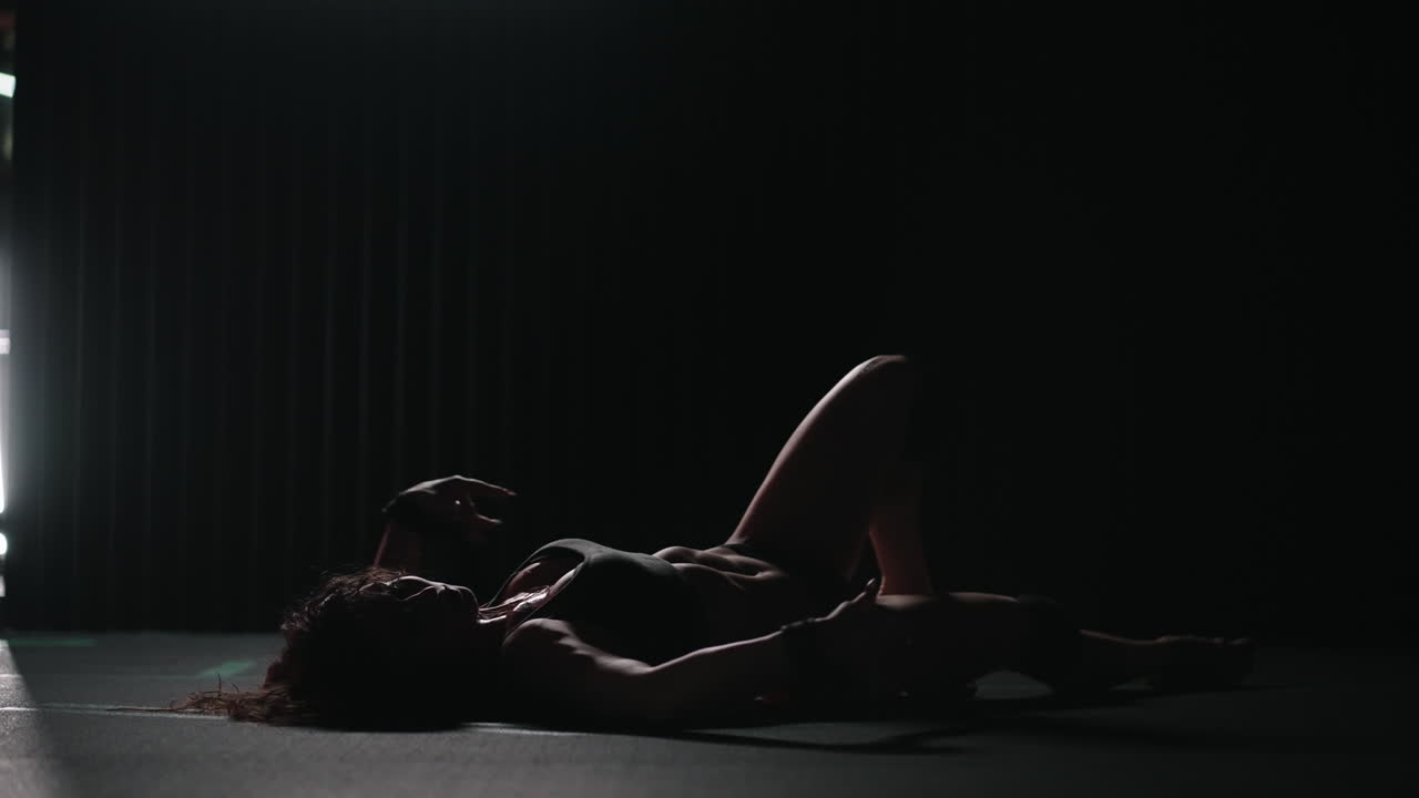 A young beautiful sexy woman dances beautifully in the gym. Modern choreography in the gym. Dancer