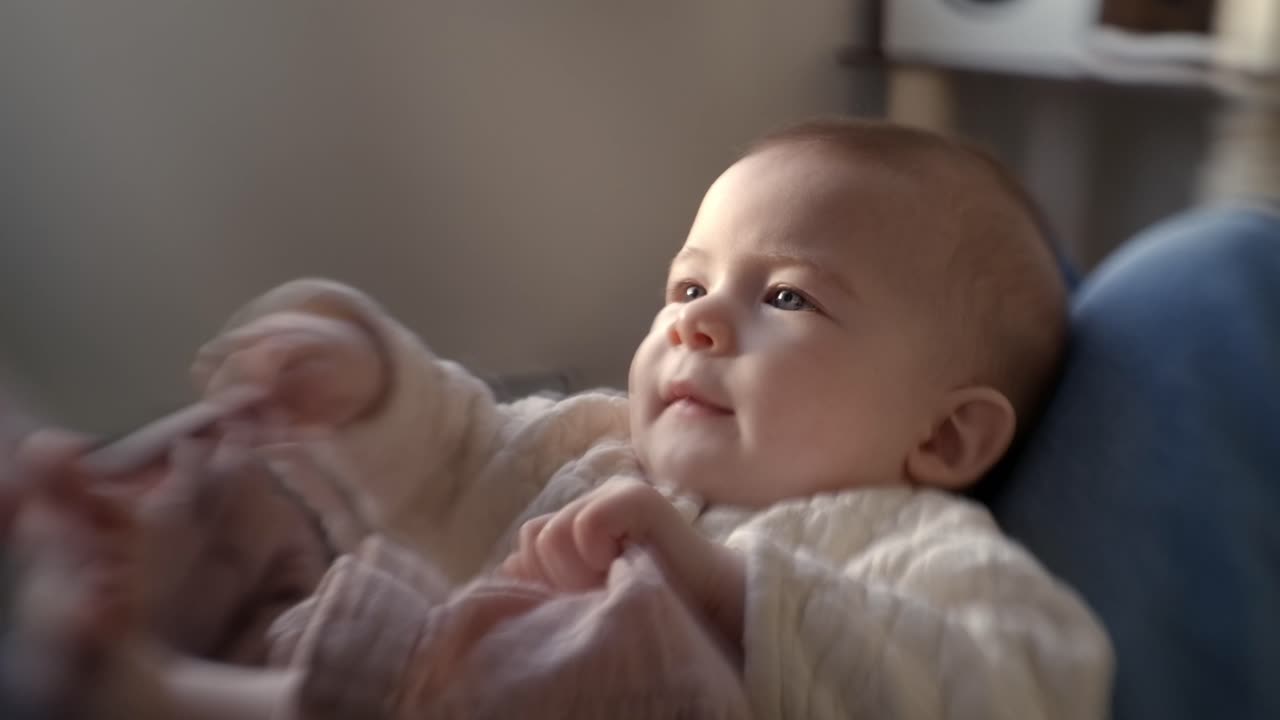 The Baby Gazes Up with Delight, Captivated by a Playful Moment Shared With Mom - Close Up