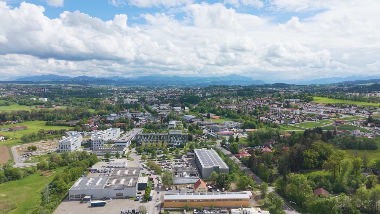 Weite Drohnenaufnahme von Kempten Allgäu, Deutschland, mit grüner Landschaft, Wohngebäuden, sanften Hügeln und sonniger bayerischer Szenerie. UHD